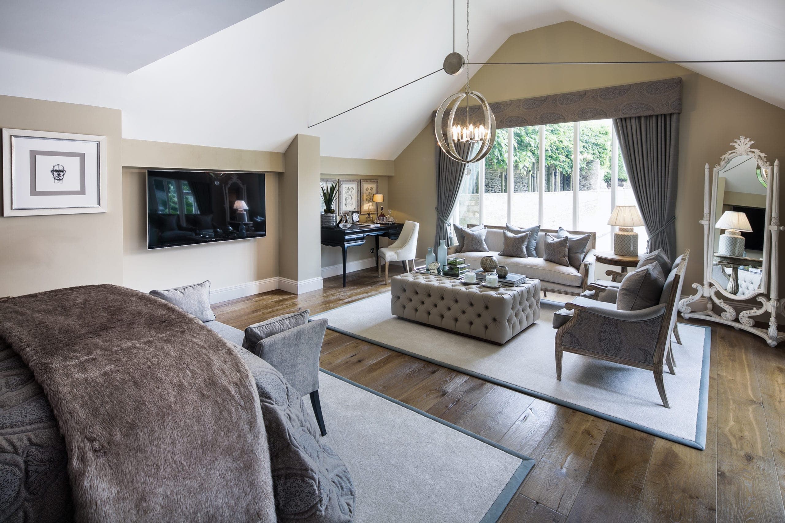 Vaulted bedroom with a sitting area and a tall window to the garden