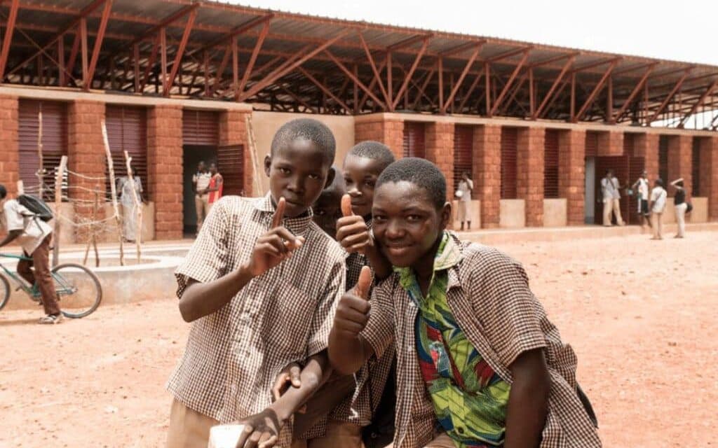 Children outside a school designed and delivered by Article 25