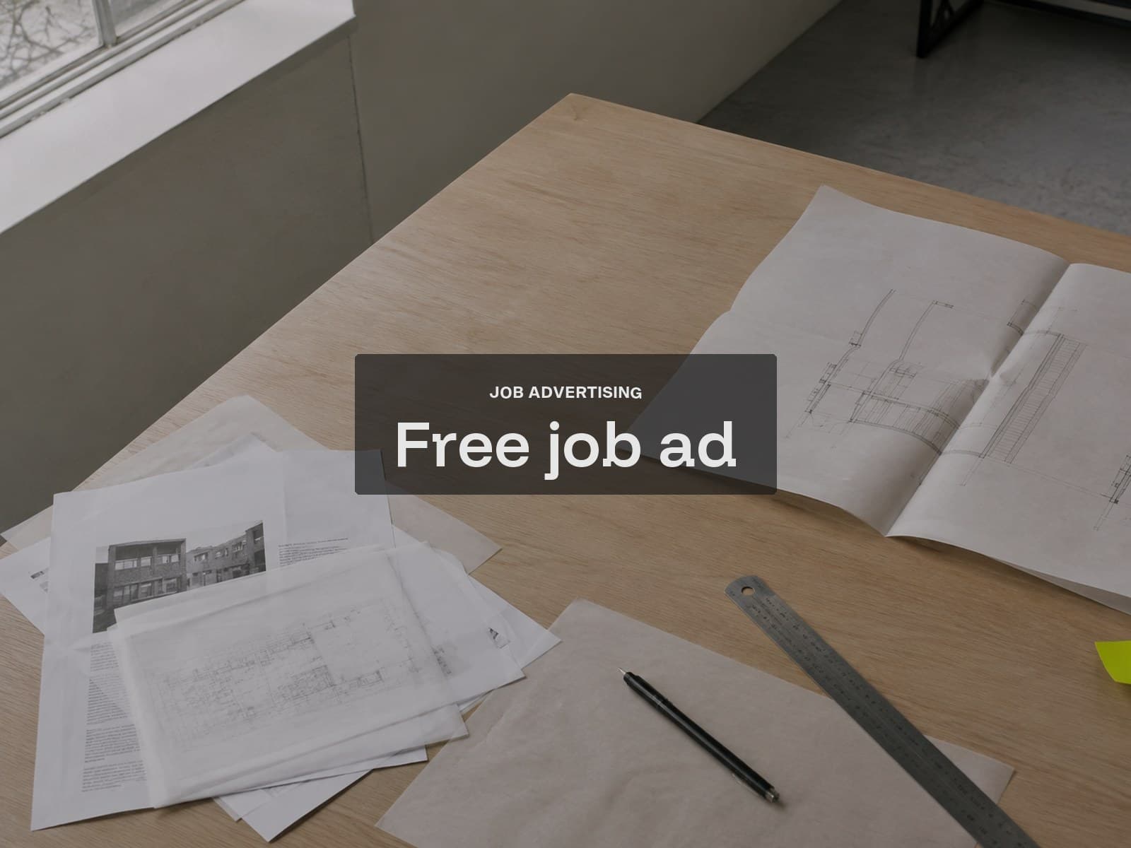 Free job advertisement cover: drawings and a scale ruler on a pale oak studio table.