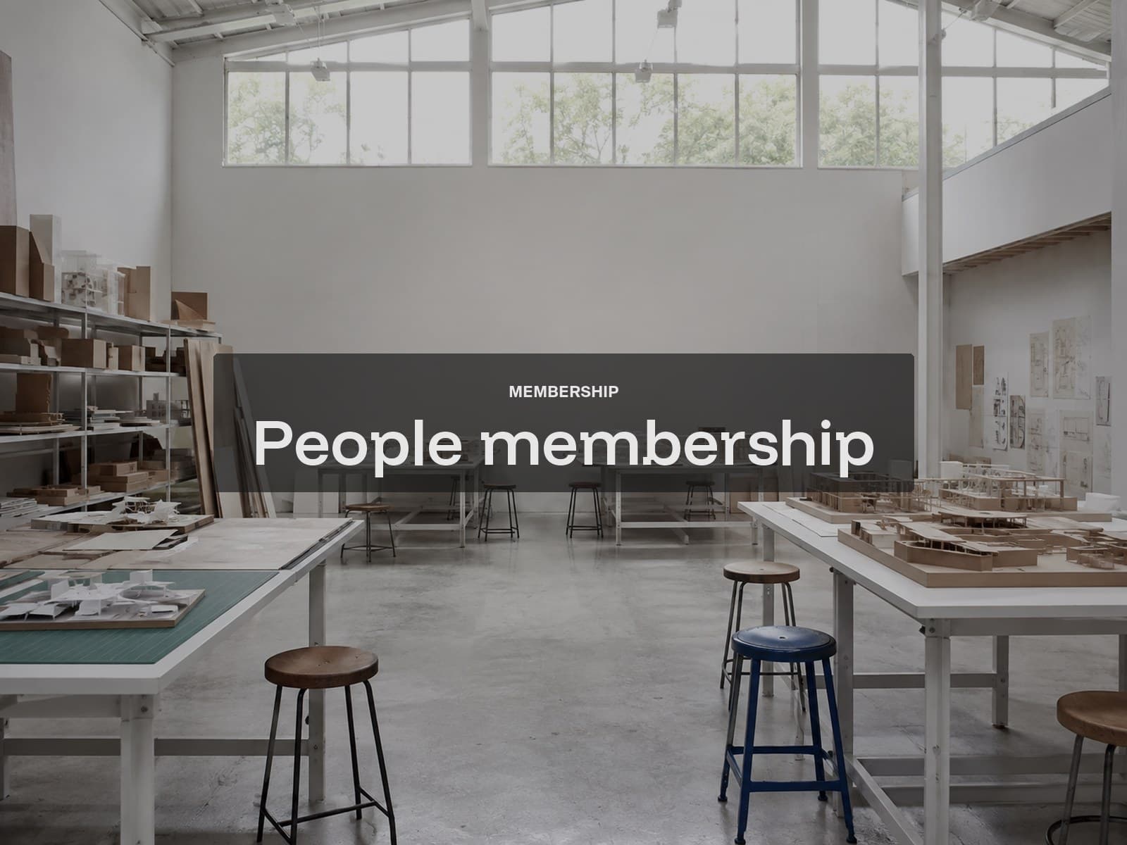 People membership cover: an empty architecture school studio with models and stools.