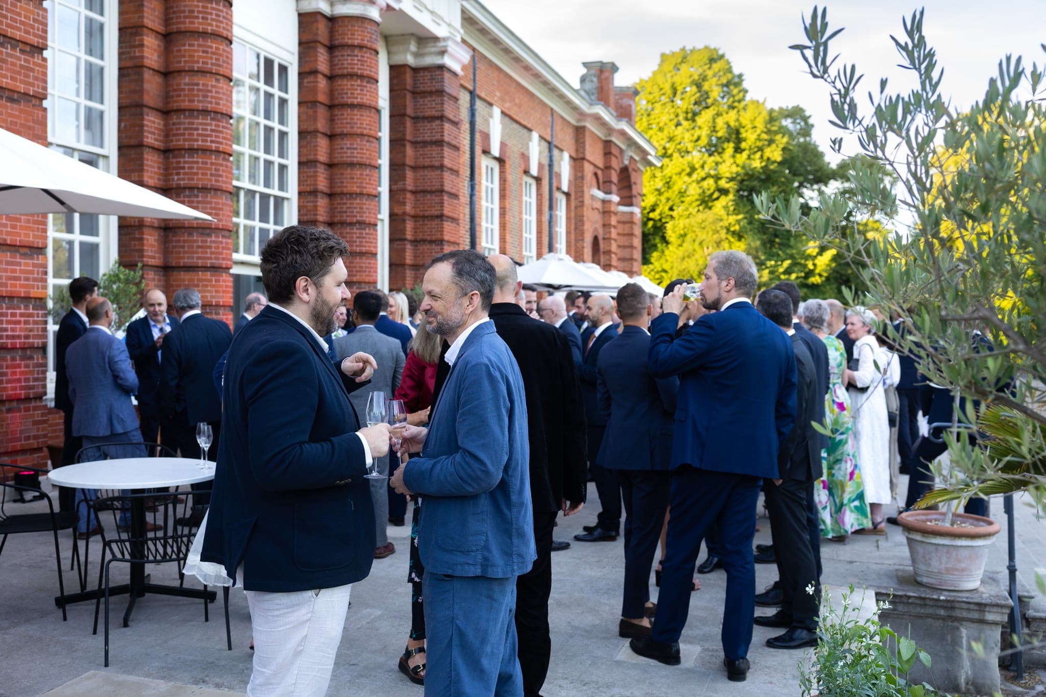 People talking outdoors at a networking event at Kensington Palace.