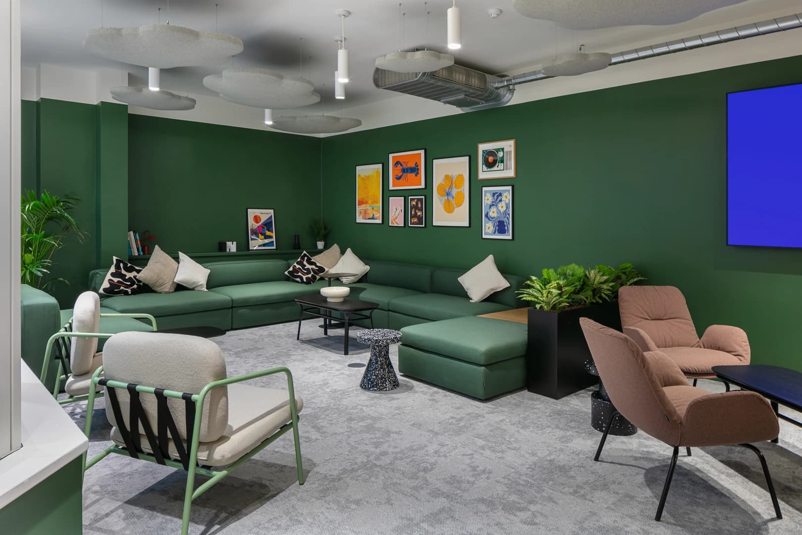 Green lounge seating and framed artwork within DF Capital’s workplace