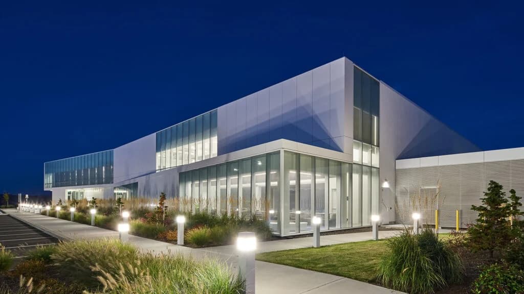 Lightbox’s illuminated glass and white metal façade at dusk