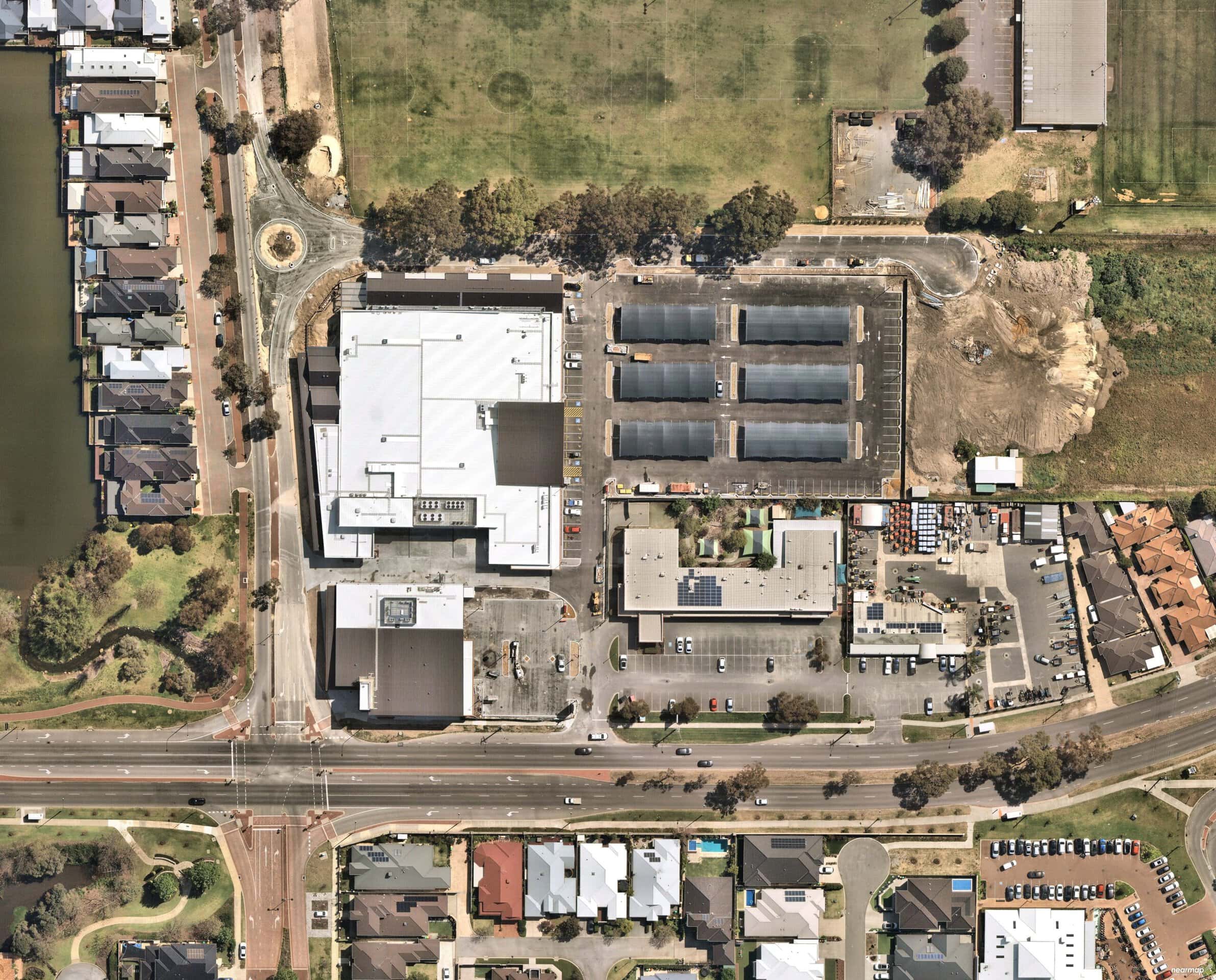 Aerial view of Roselea Shopping Centre, its car park and the surrounding roads and houses.