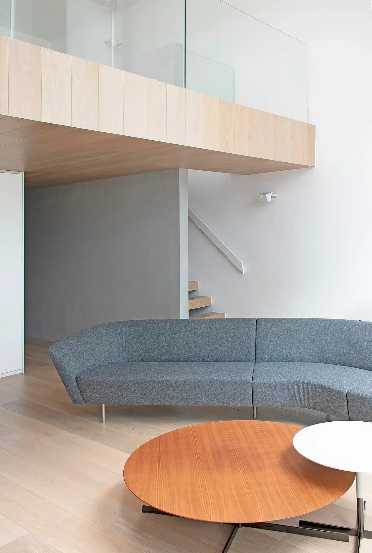 The timber gallery projects above the sofa in the double-height living room.