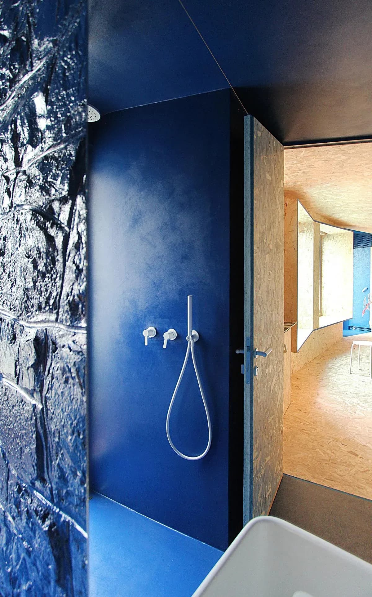 Glossy blue surfaces and white fittings define the bathroom.
