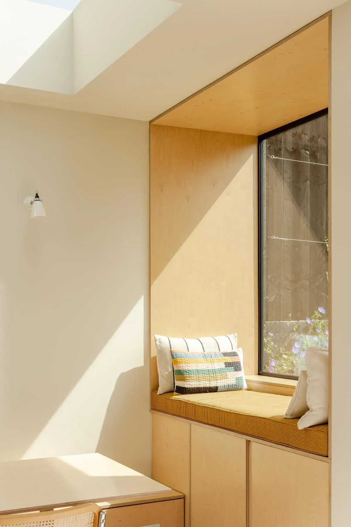 A built-in window seat creates a place to sit beside the garden.