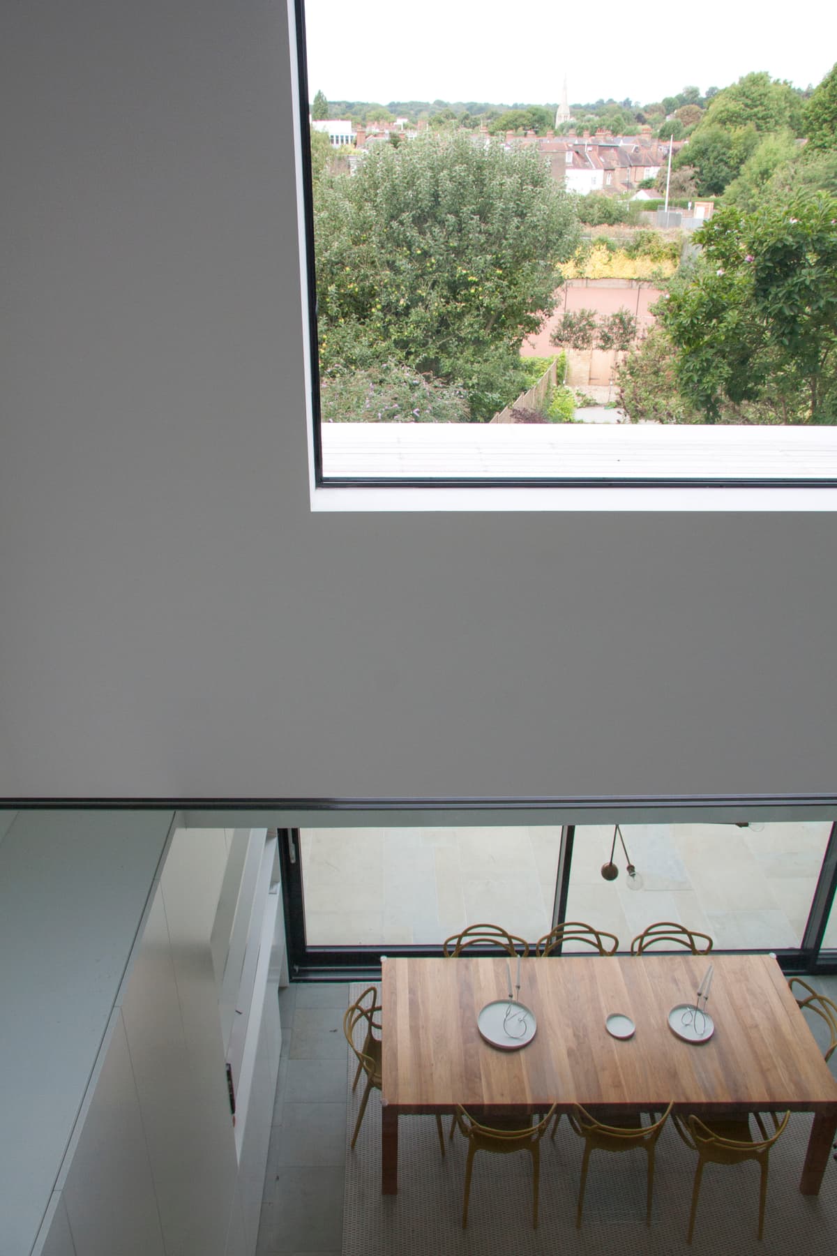The dining table and garden are visible through the double-height void at Vertical Intersect.