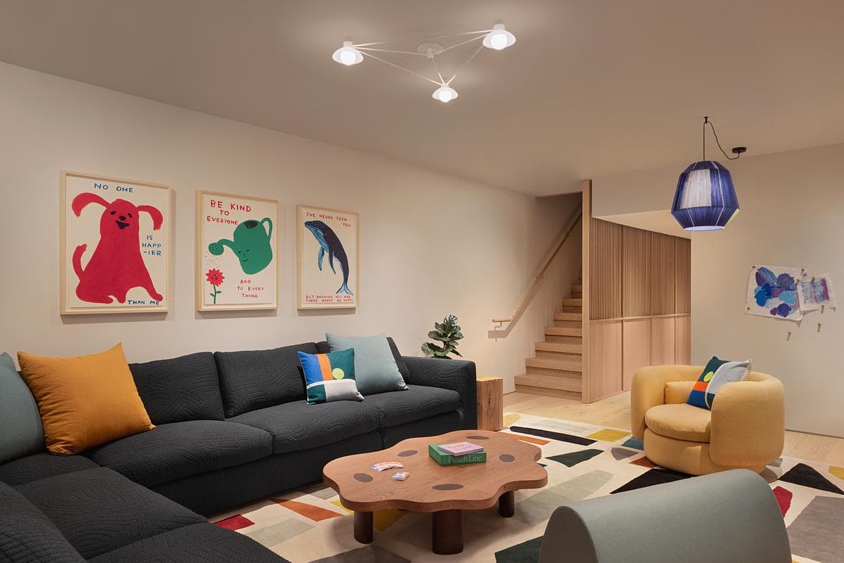 Colourful furnishings sit beside the timber stair in a family living room.