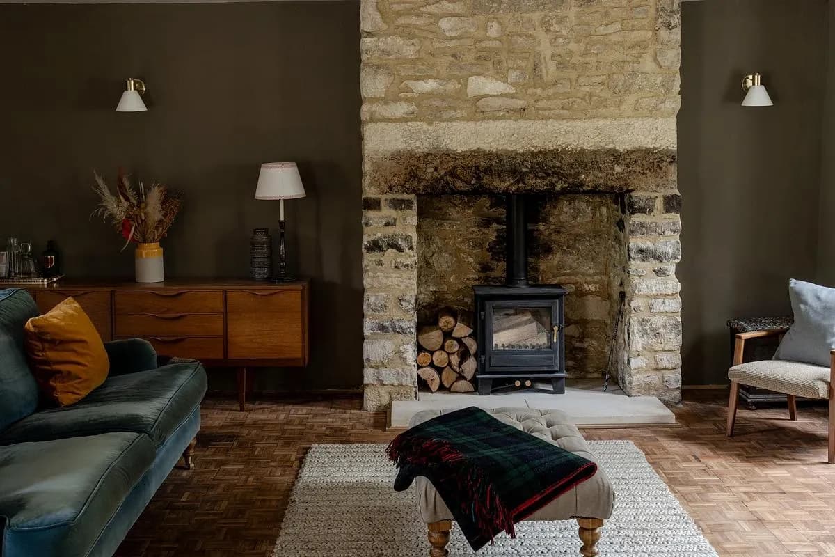 The cottage's sitting room keeps its stone fireplace and wood-burning stove.