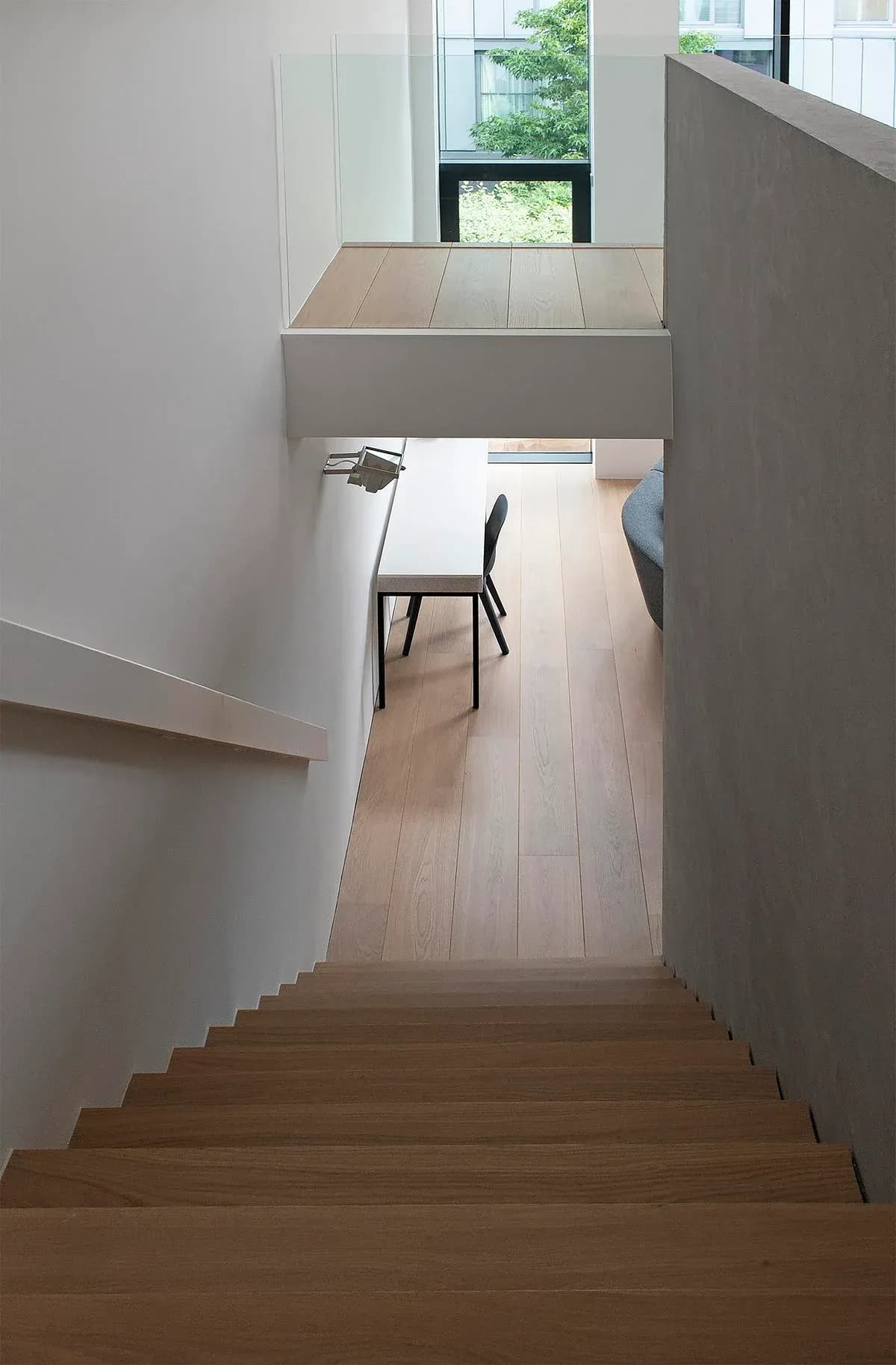 The stair descends past the gallery towards the living and dining level.