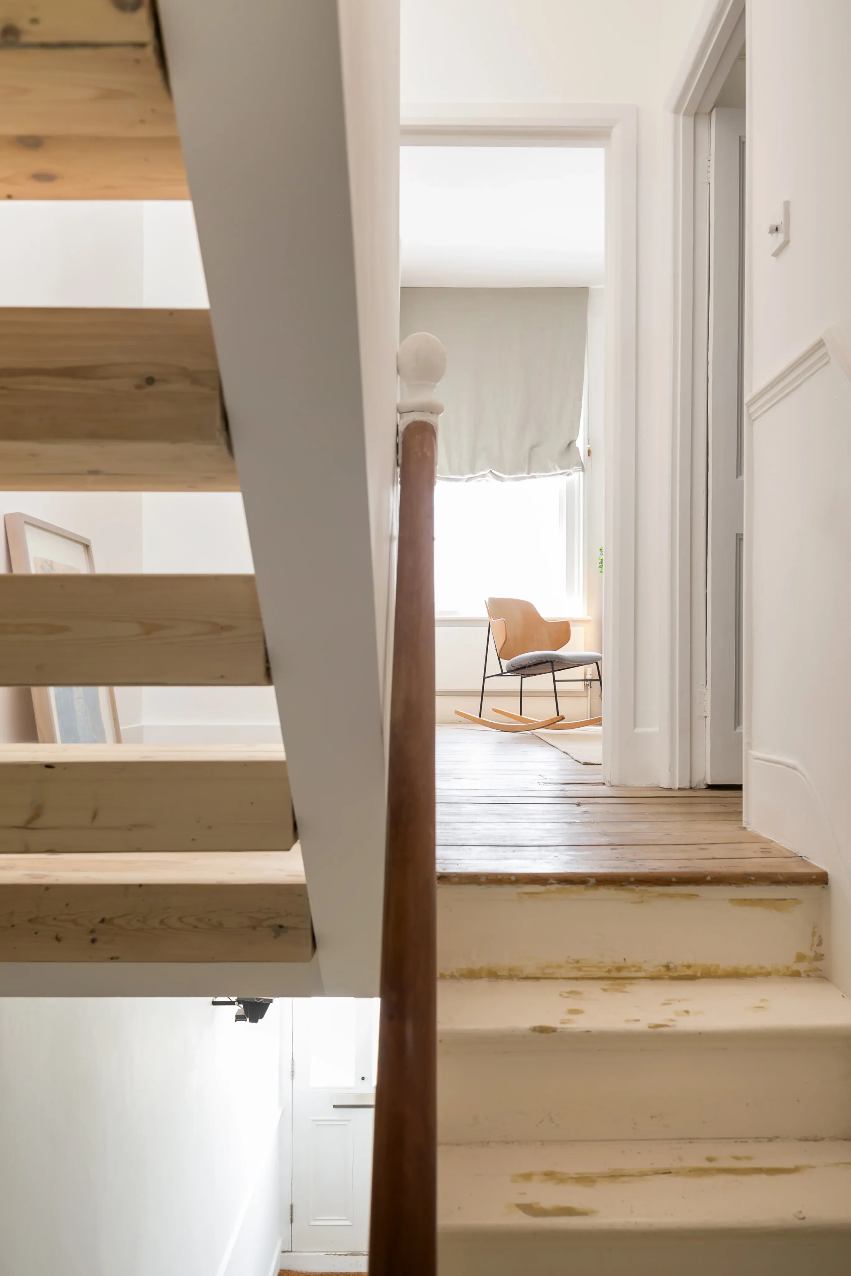 Open timber stair treads preserve views between the house’s levels.