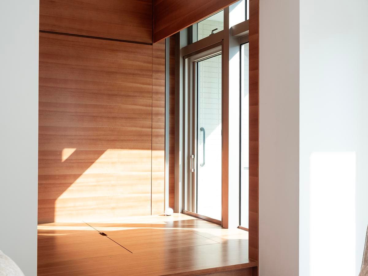 Timber lining and built-in storage define the bedroom platform beside the window.