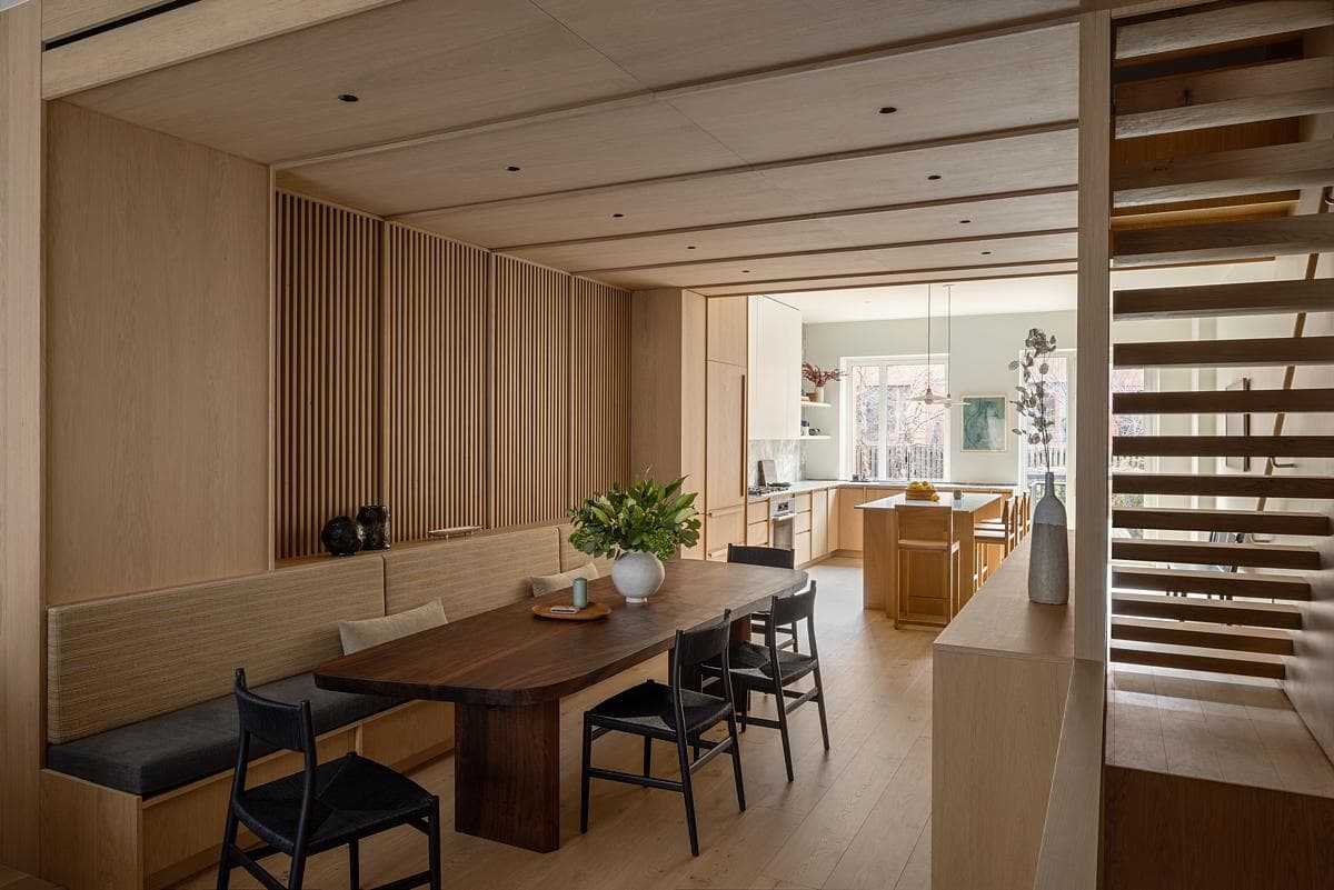Oak screens and fitted seating connect the dining space with the stair and kitchen.