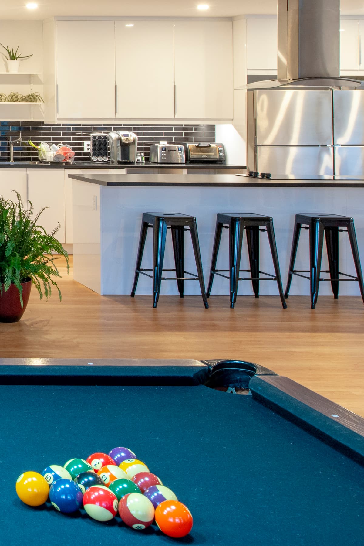 The kitchen and lounge include bar seating and a pool table.