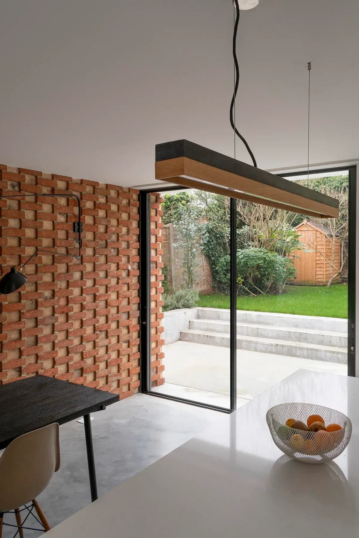 The dining space opens to the garden beside the relief brickwork wall.