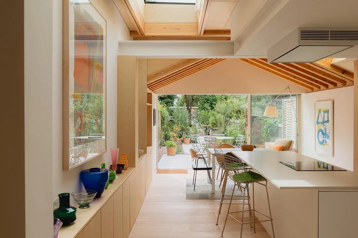 A pitched timber ceiling carries the view through the kitchen to the garden.