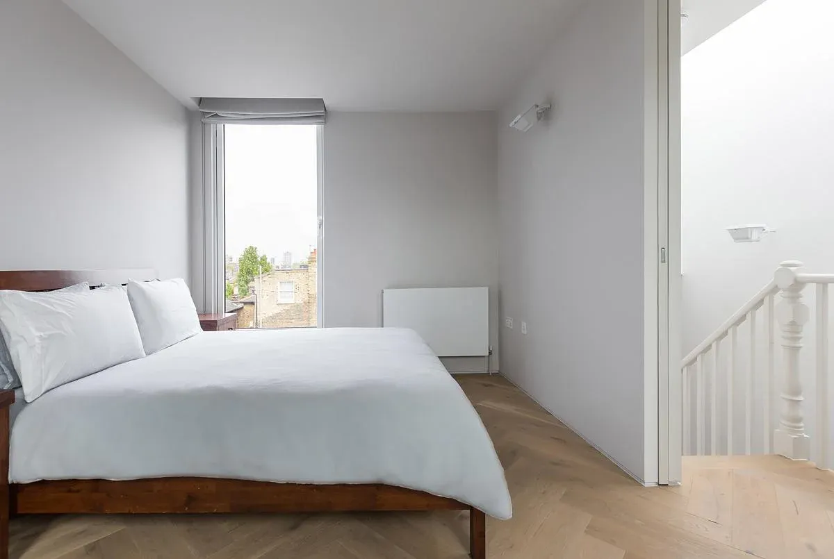 The upper bedroom retains the house’s pitched roof profile.