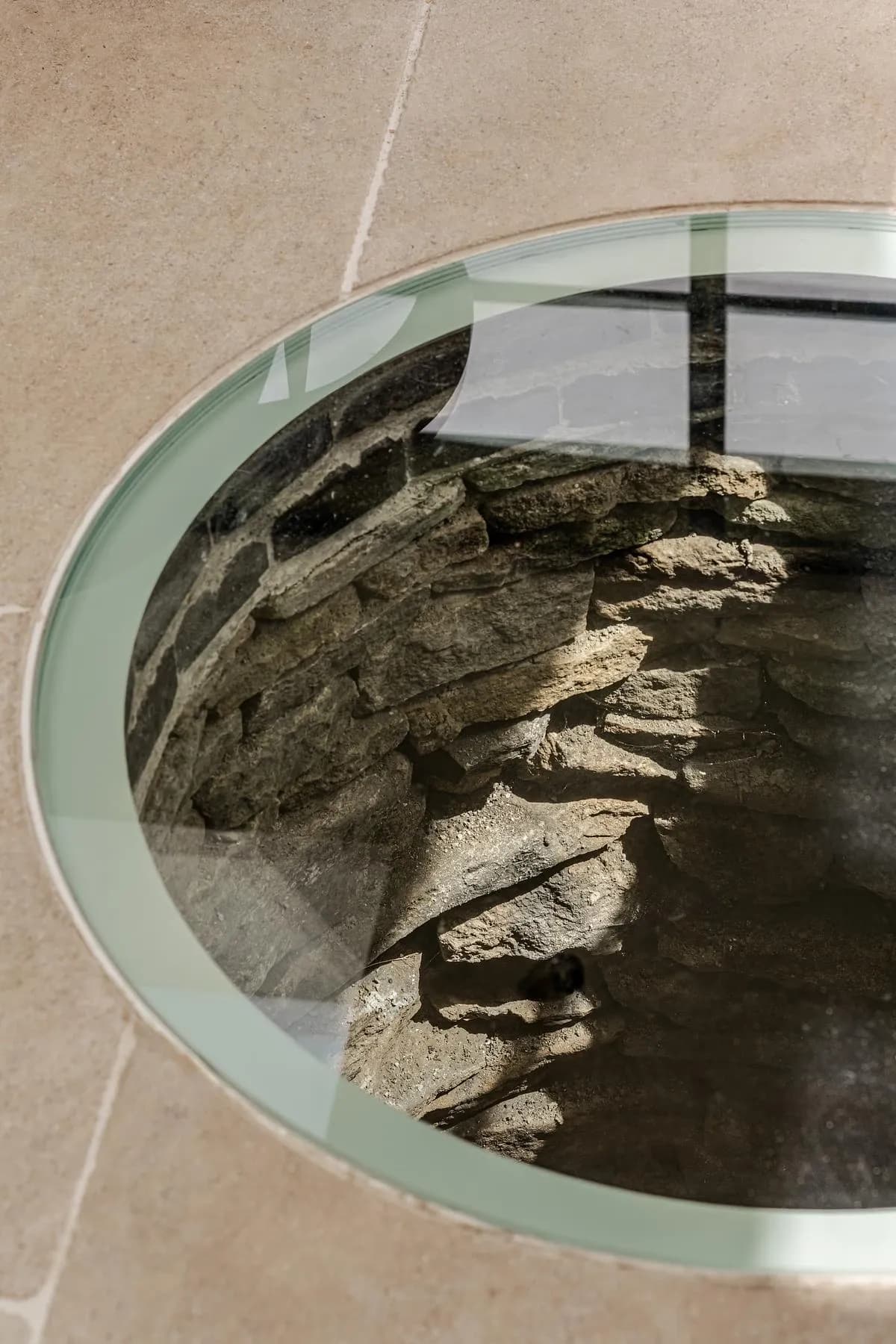 The well uncovered during excavation, seen through its glass cover.