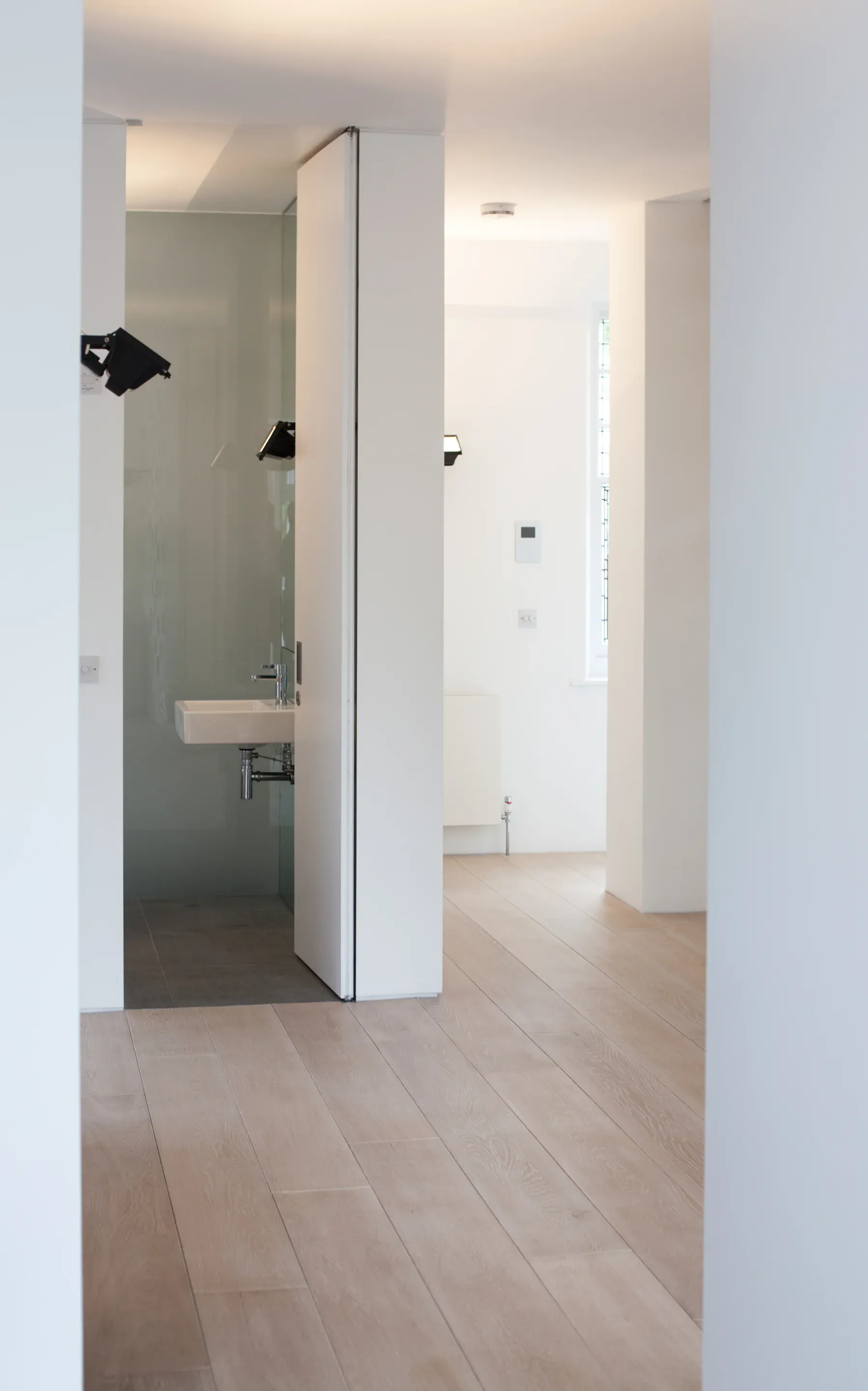 A full-height opening connects the room with a compact shower space.