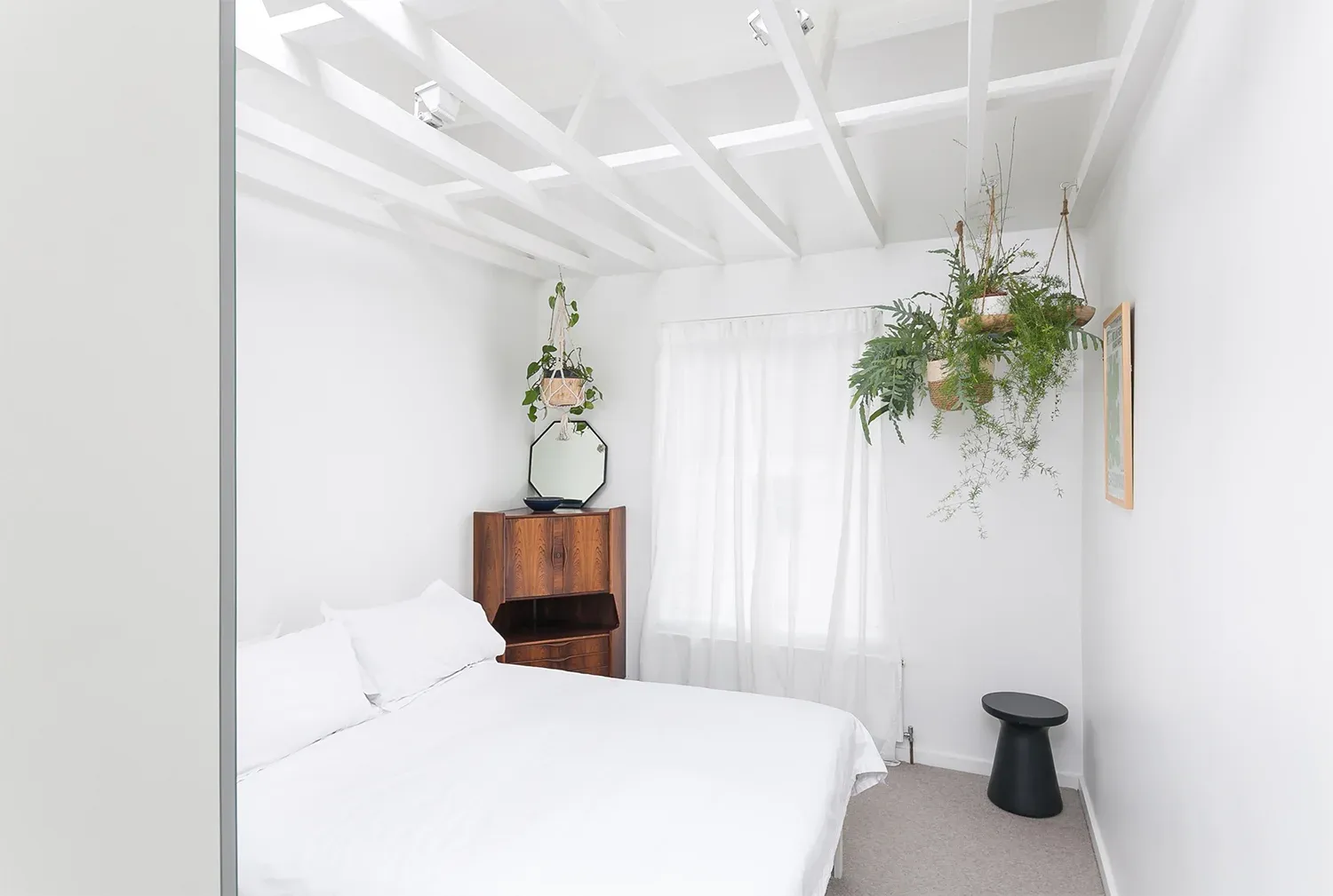 Exposed ceiling beams and a rooflight increase the bedroom’s sense of height.