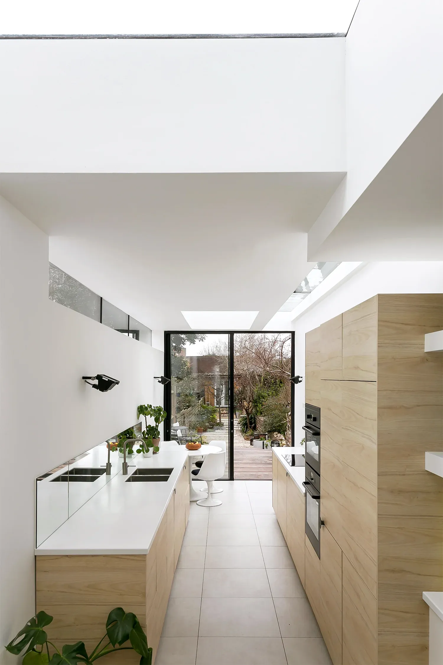 Rooflights bring daylight above the narrow kitchen and its timber joinery.