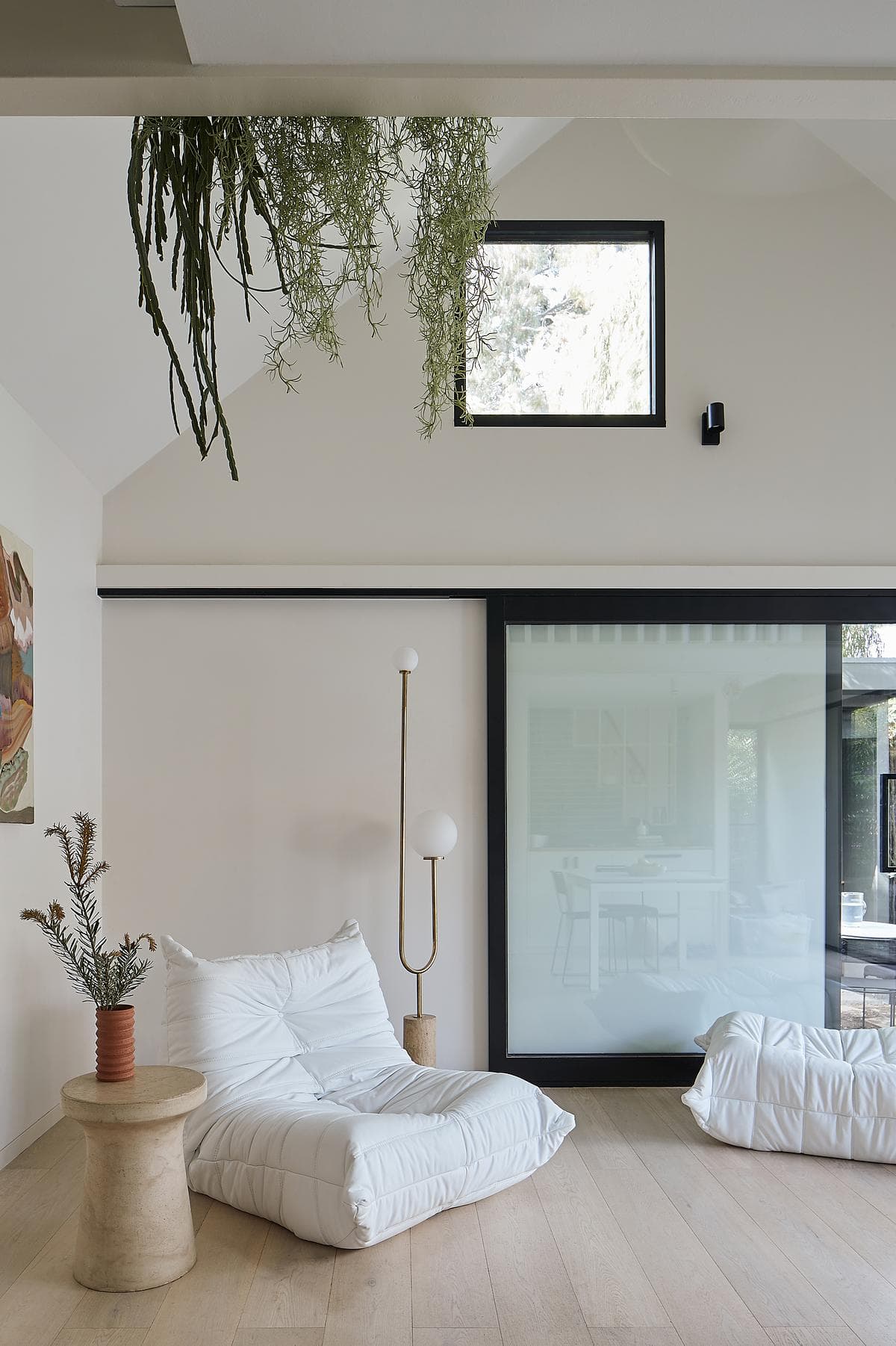 A tall window brings daylight into the living space beneath the mezzanine.