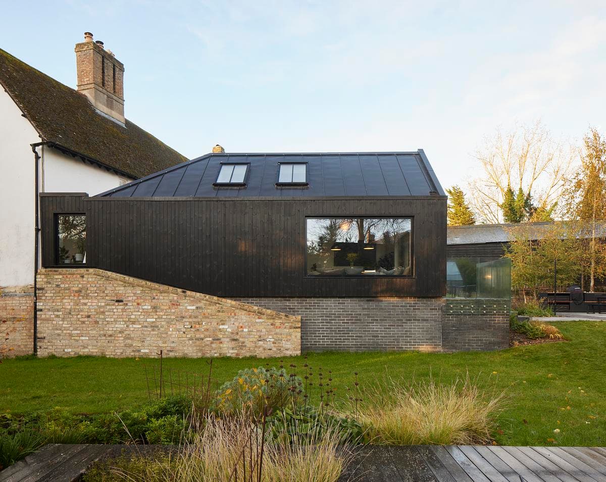 A side view of the extension, with its zinc roof and the retained garden wall.