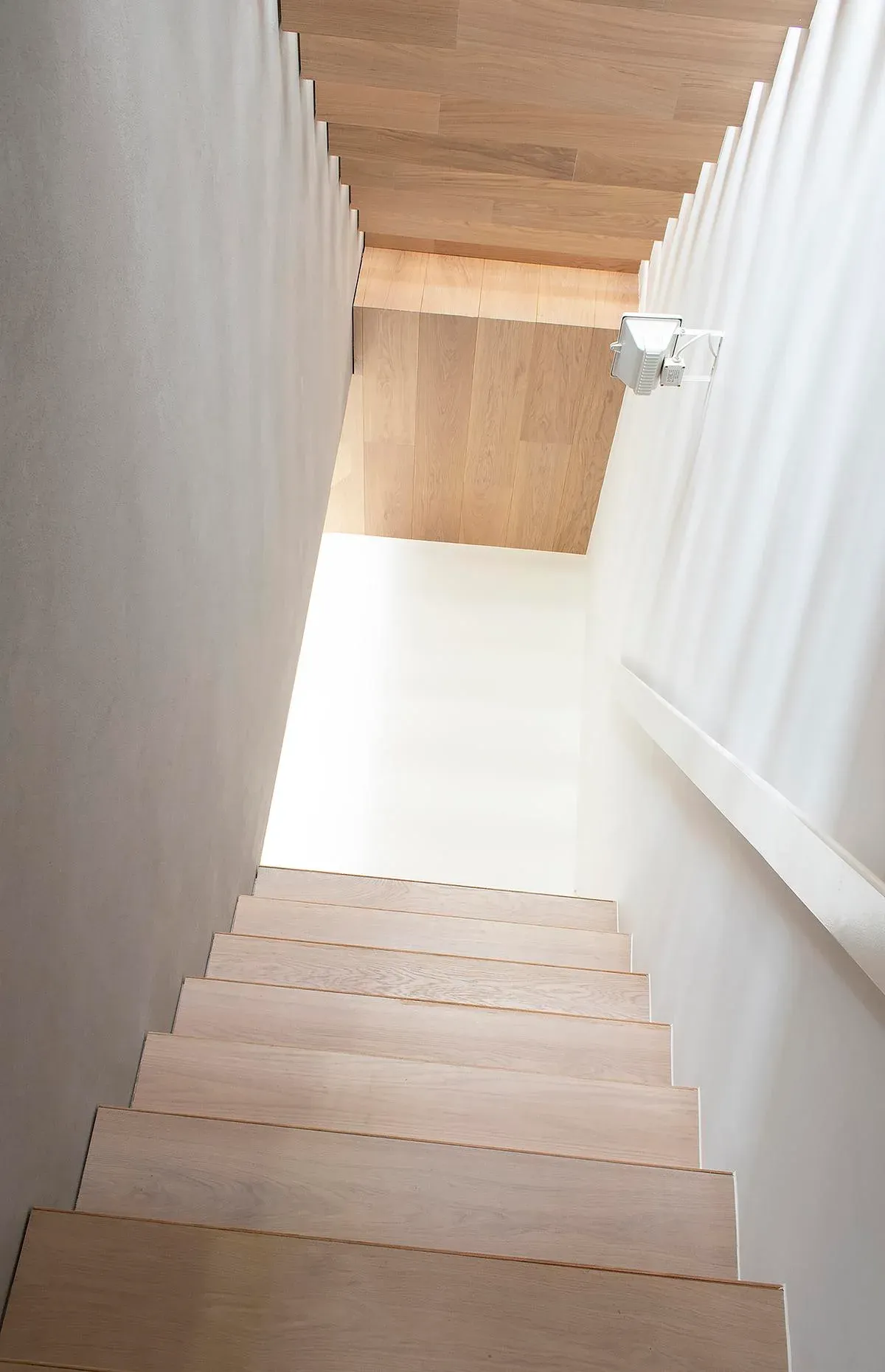 White stair guarding frames the timber treads and ceiling.