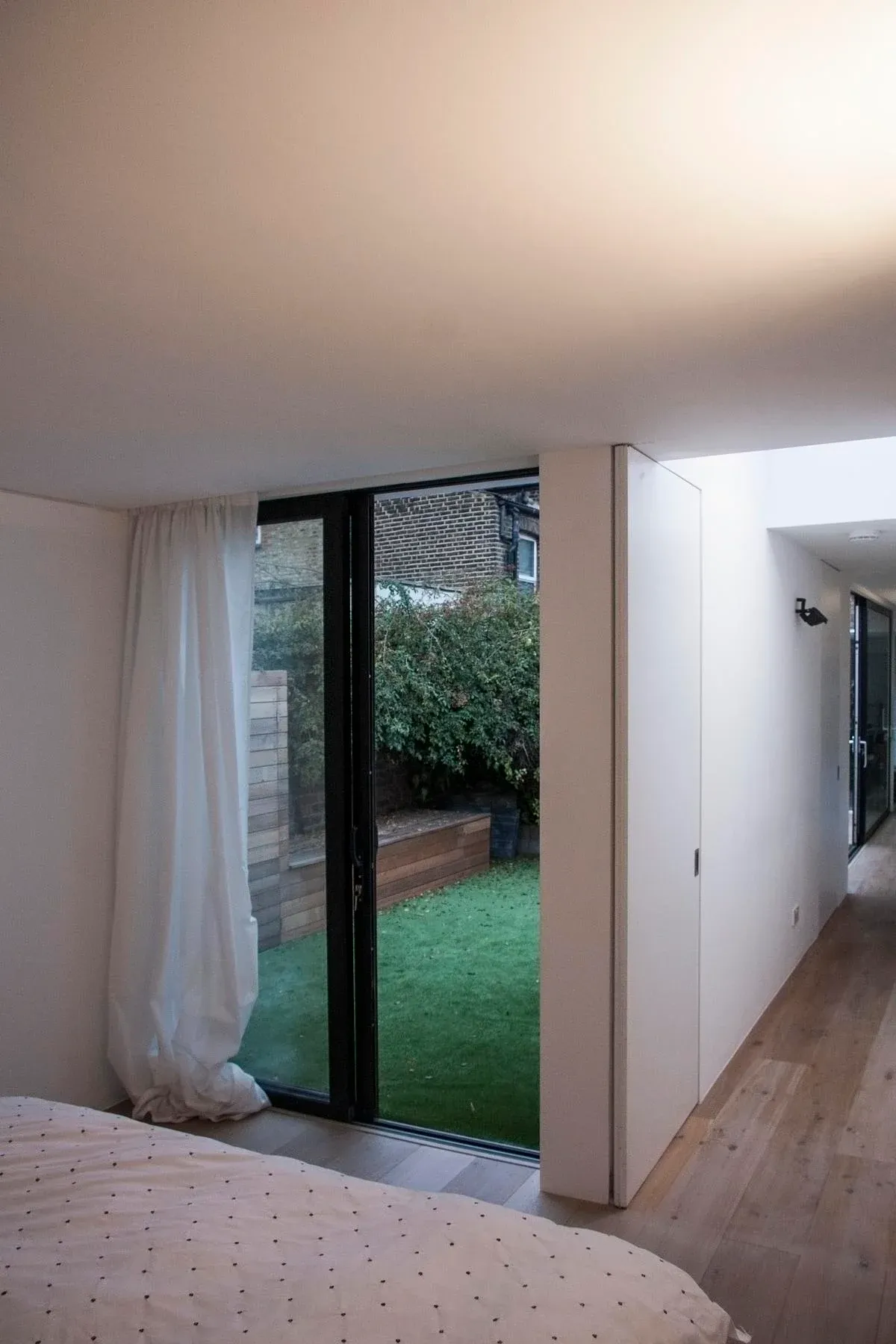 The bedroom opens onto the courtyard beside a white storage volume.