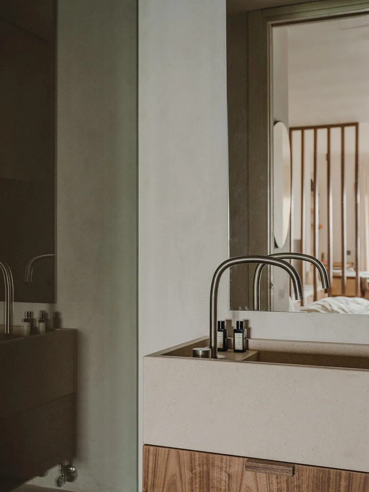 The bathroom mirror frames a view back into the bedroom.