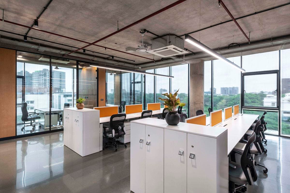 Open workstations share a glazed office floor.