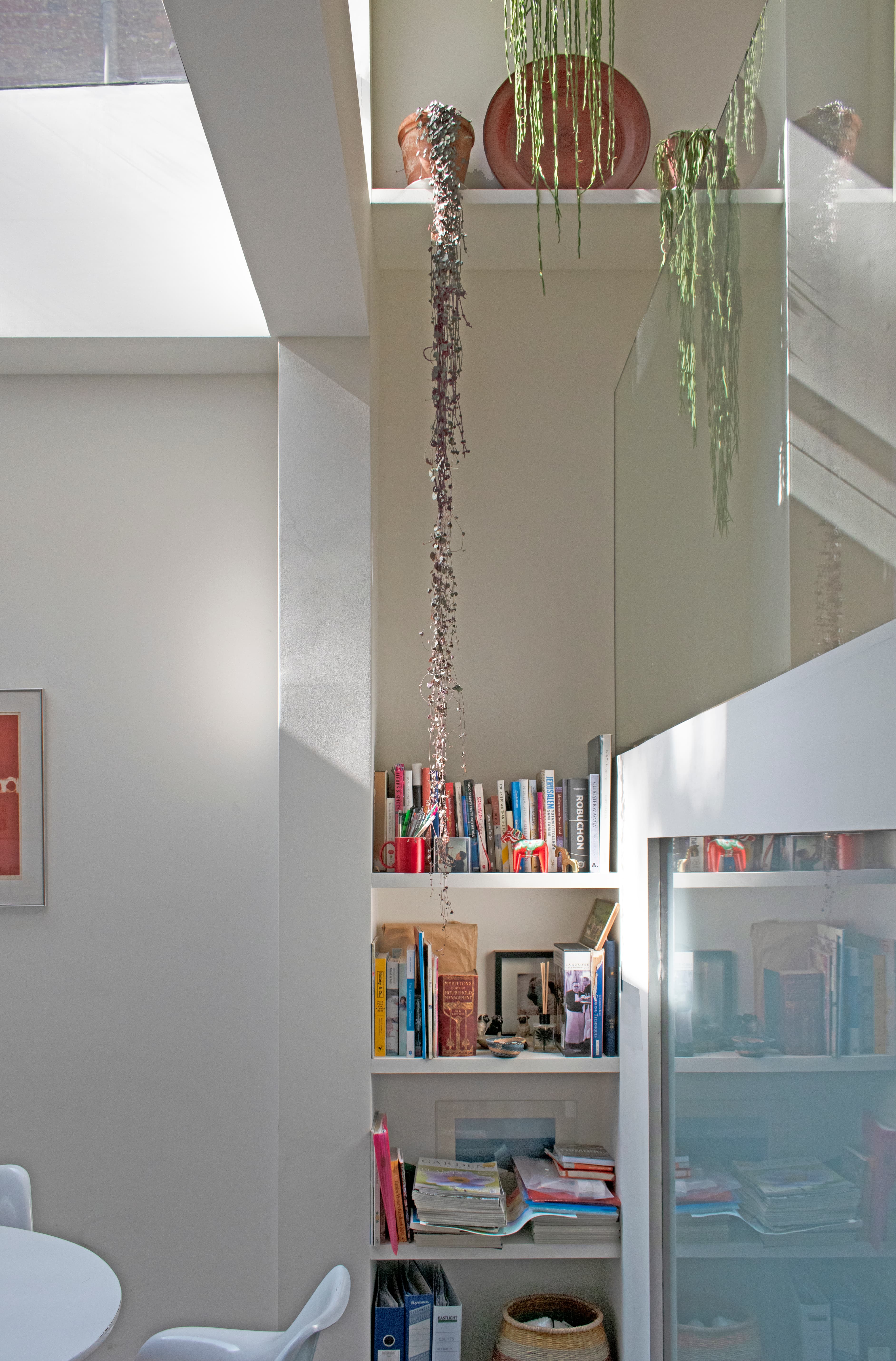Shelving and frosted glazing connect the different interior levels at Structuralist House.
