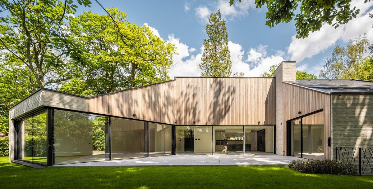 A glazed garden elevation opens onto the lawn and terrace.