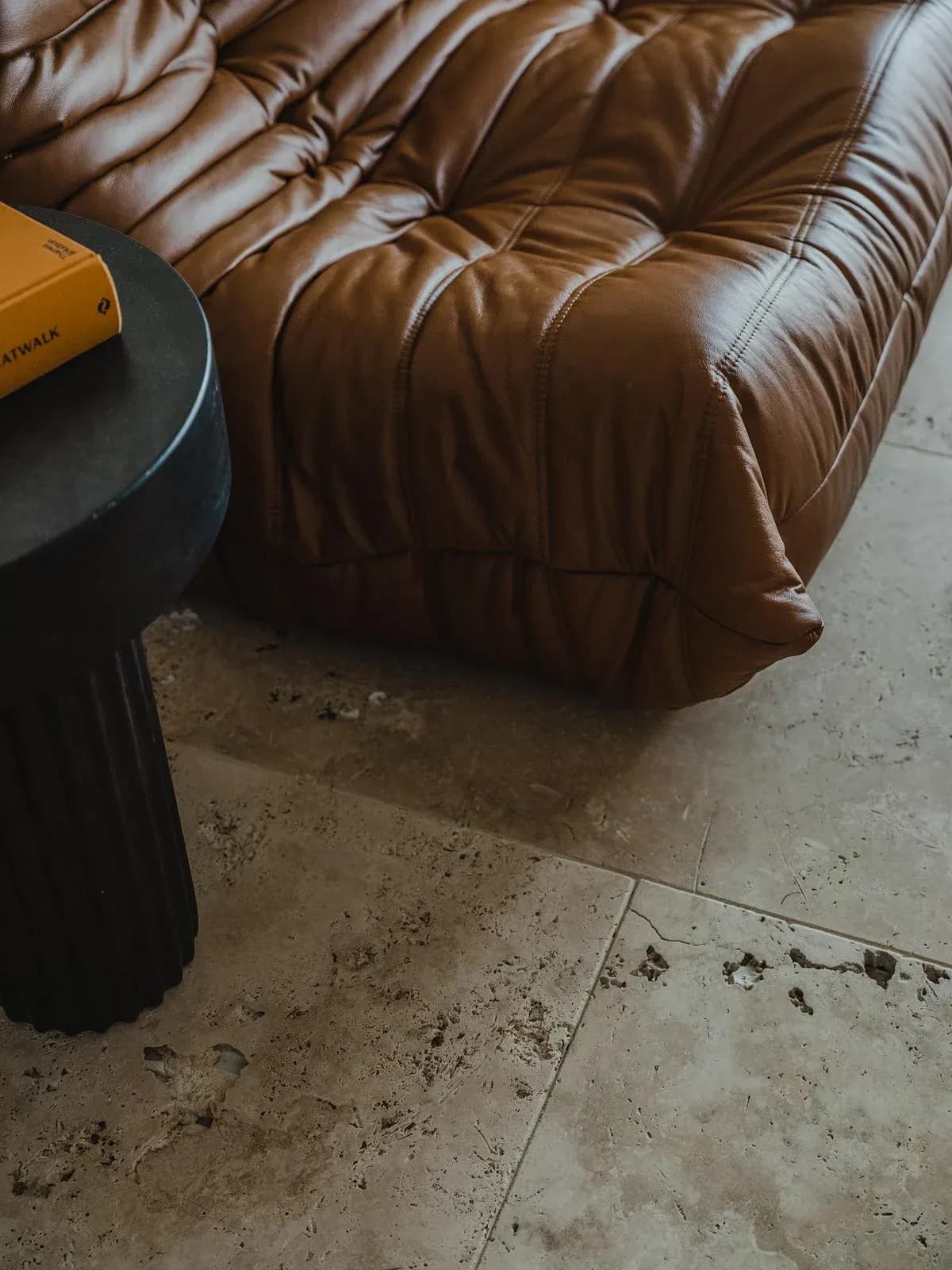 Leather upholstery and travertine bring texture to the sitting area.