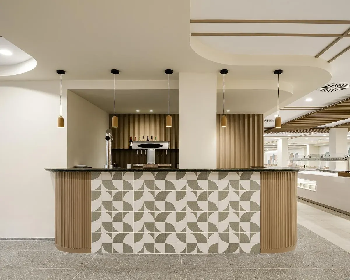 Patterned tiles and fluted timber clad a curved bar counter.