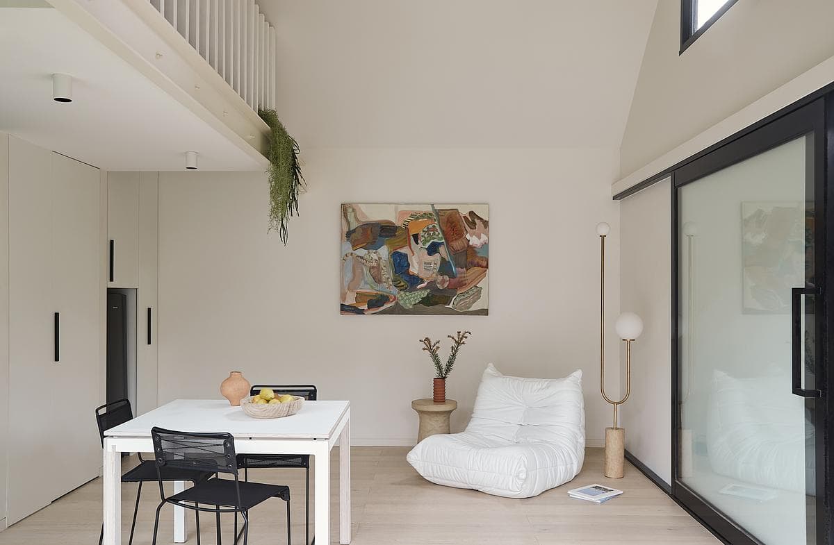 A high ceiling and large sliding openings give the small room long views.