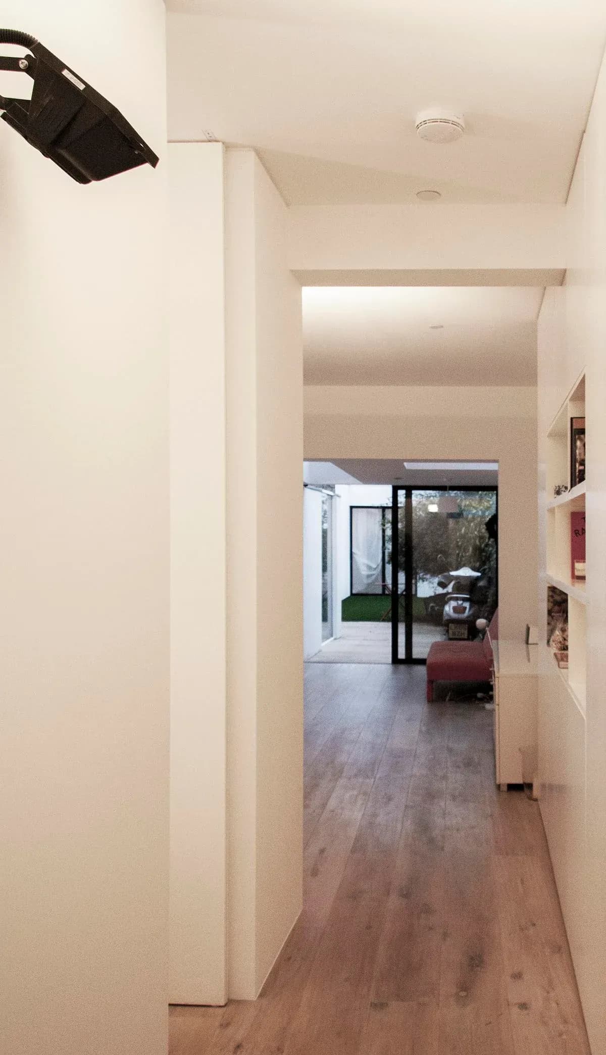 White partitions and timber flooring mark the route through the elongated home.