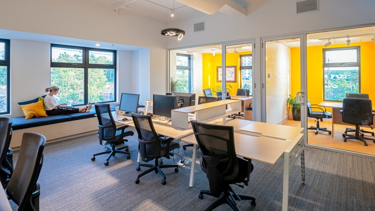 Yellow accents and daylight distinguish another part of the open office.