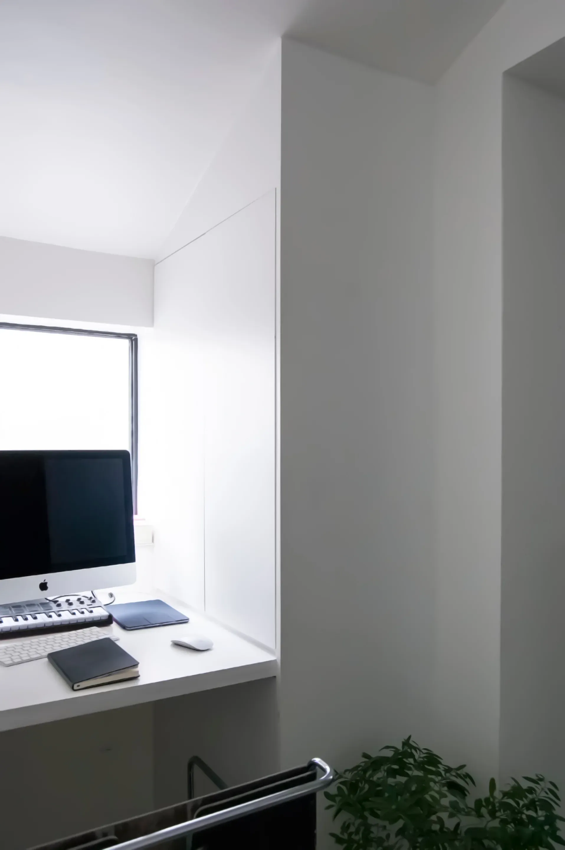 A desk occupies the naturally lit space beneath a window.