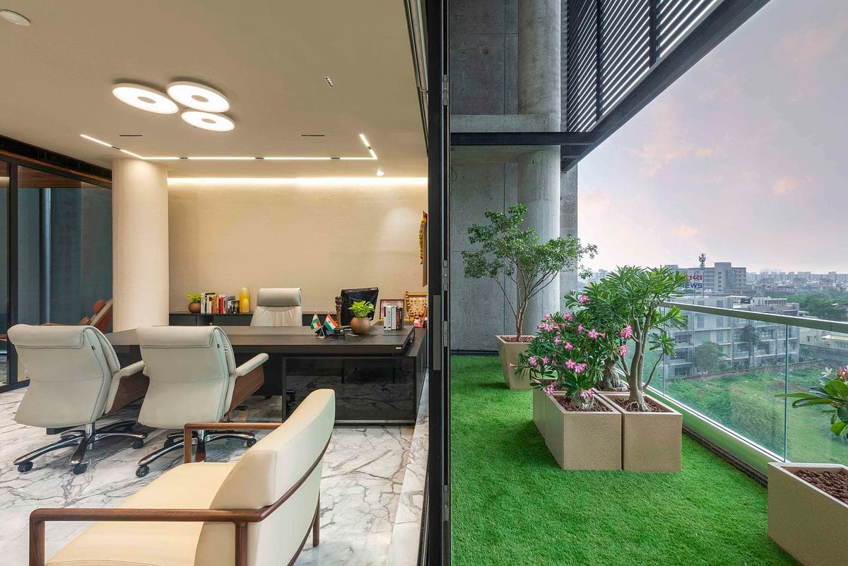 A glazed office edge looks towards the planted terrace.