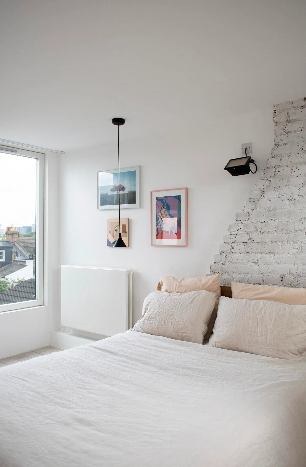 White-painted brickwork remains visible beside the bedroom.