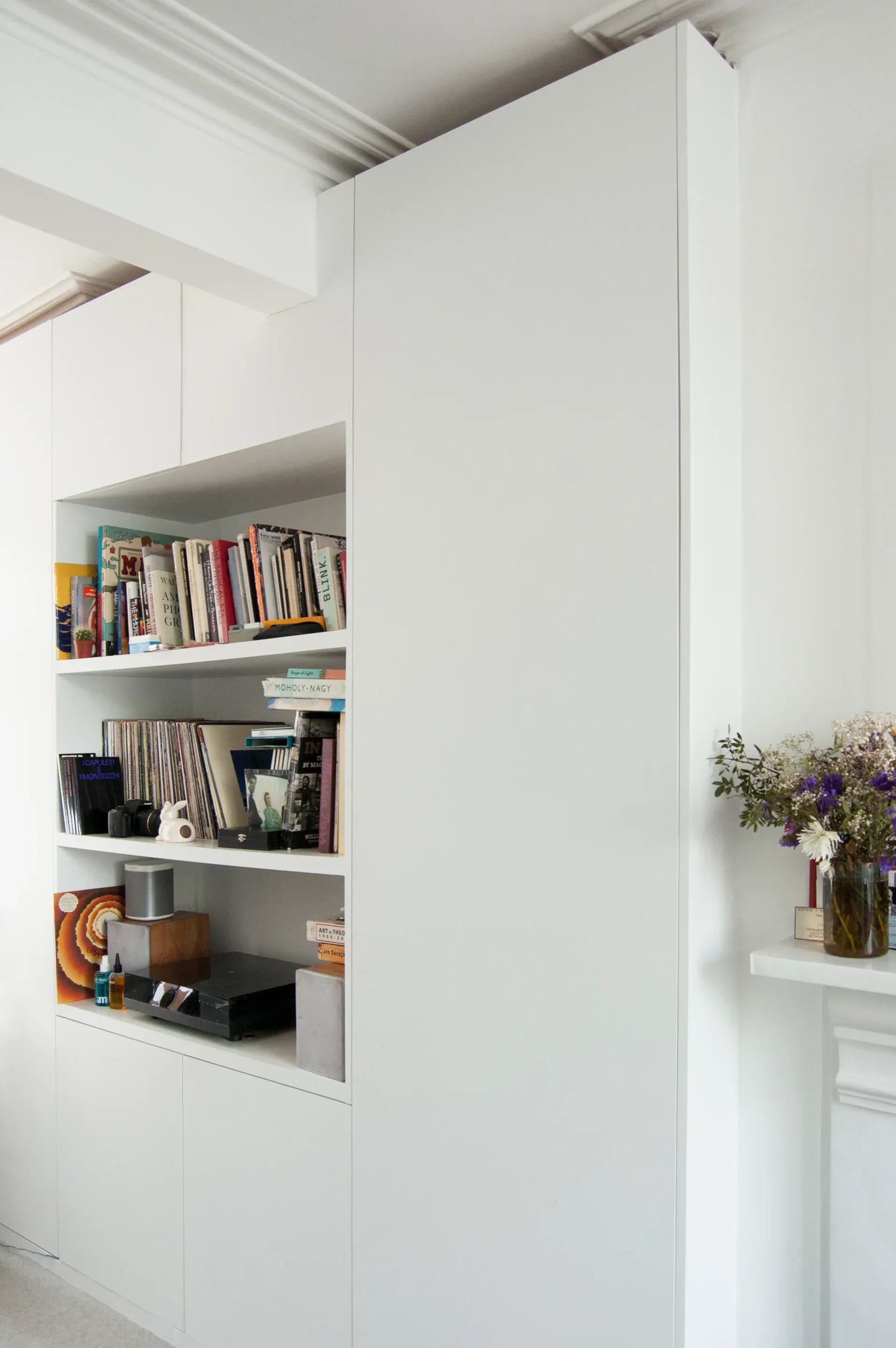 Built-in shelves and cupboards sit within a crisp white wall plane.