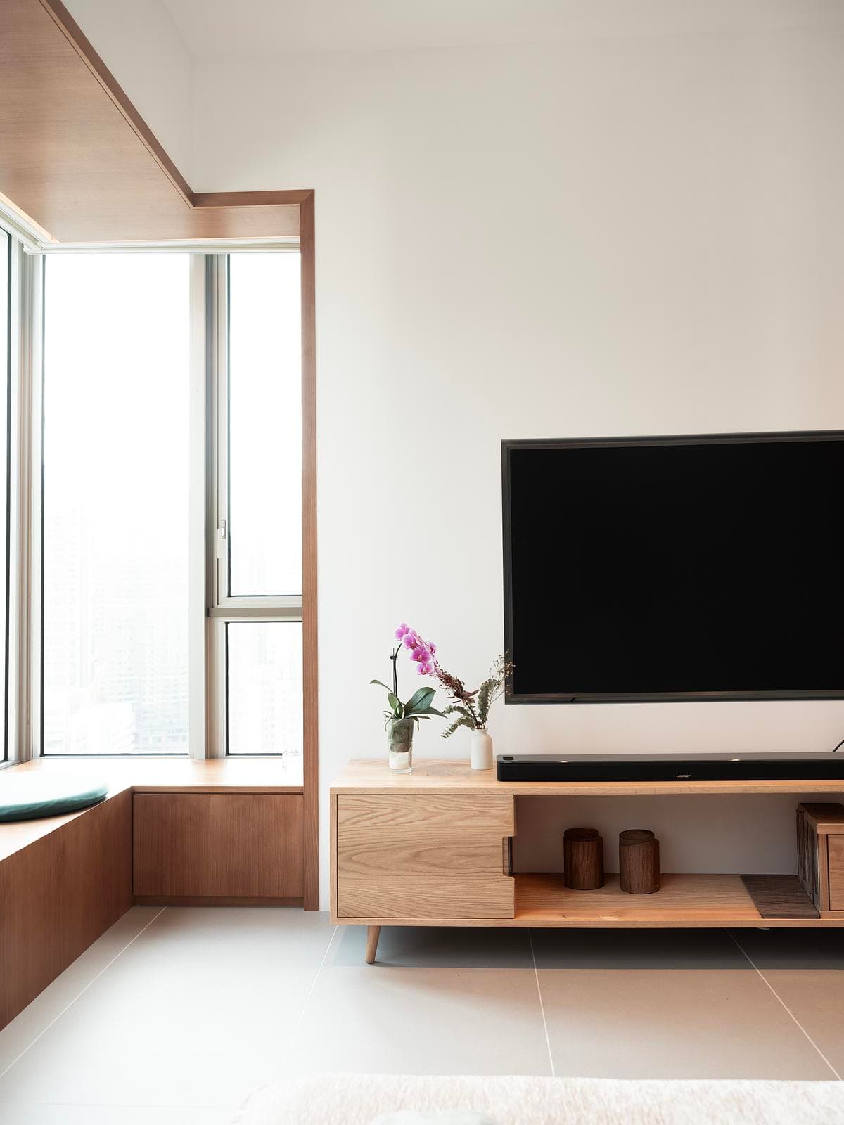 The living area combines a city-facing window with low fitted joinery.