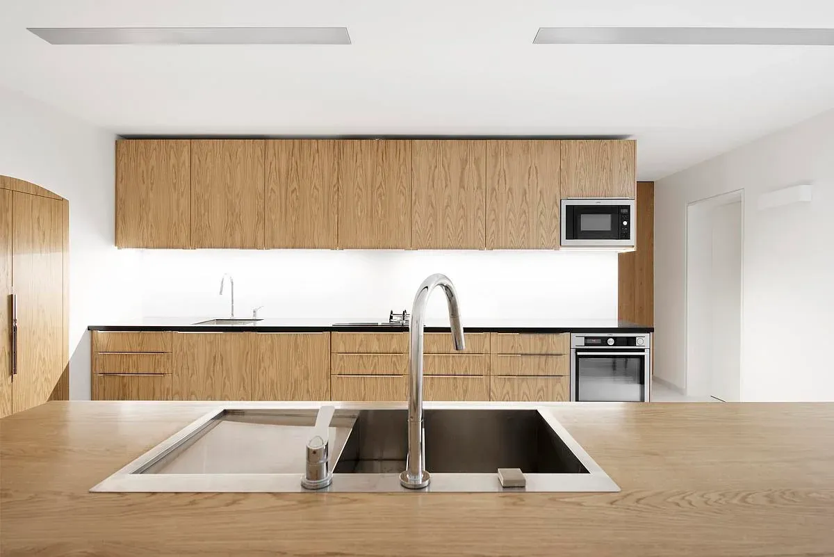 Timber cabinets and pale worktops in the embassy kitchen.