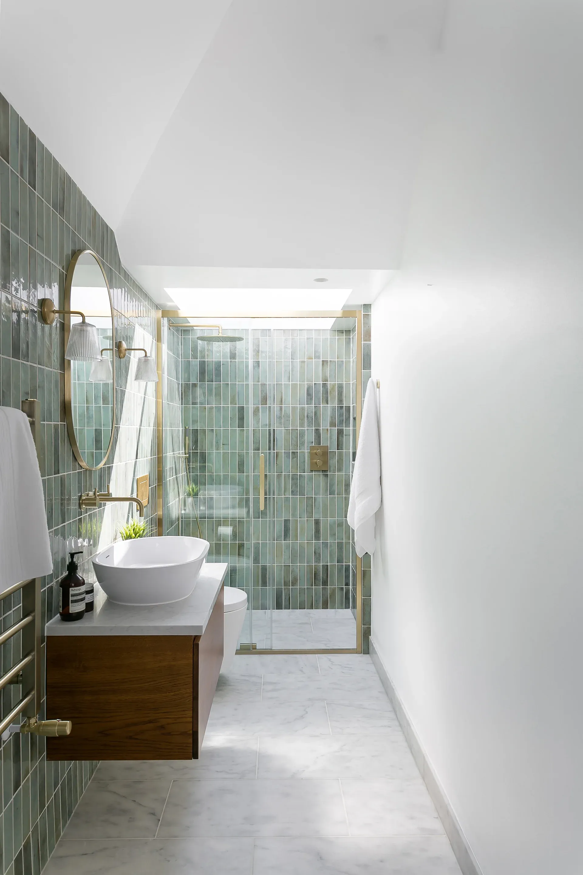 A rooflight brings natural light into the long, tiled shower room.
