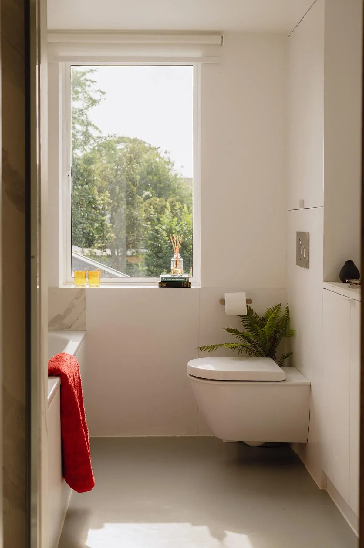 The cottage bathroom is lit by its tall sash window.