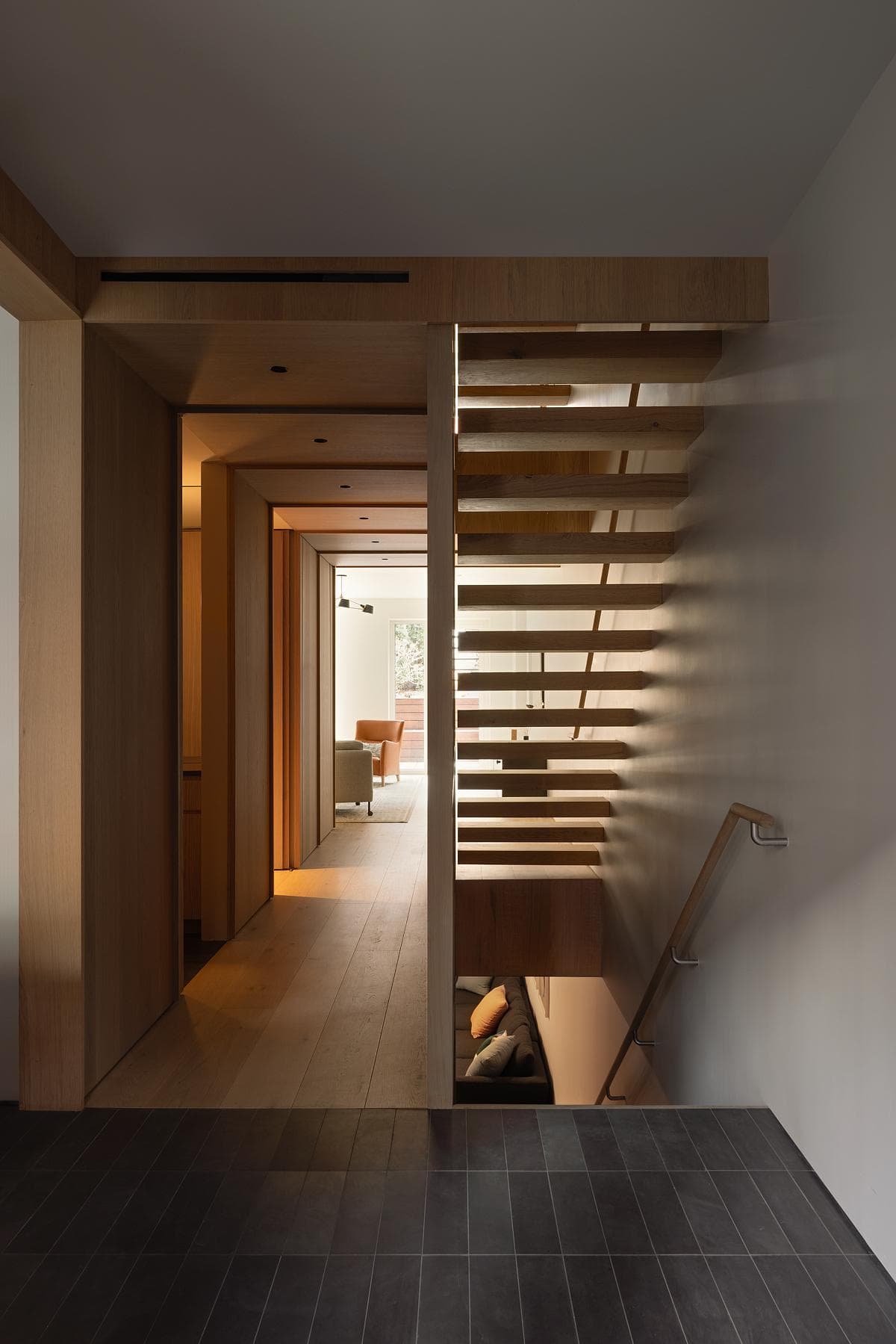 A slatted stair screen carries the timber language between floors.