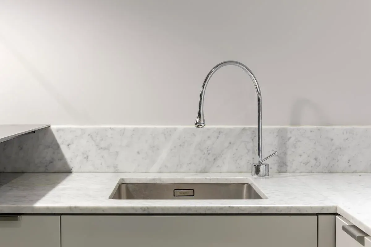 A stone splashback and stainless-steel sink in the apartment kitchen.