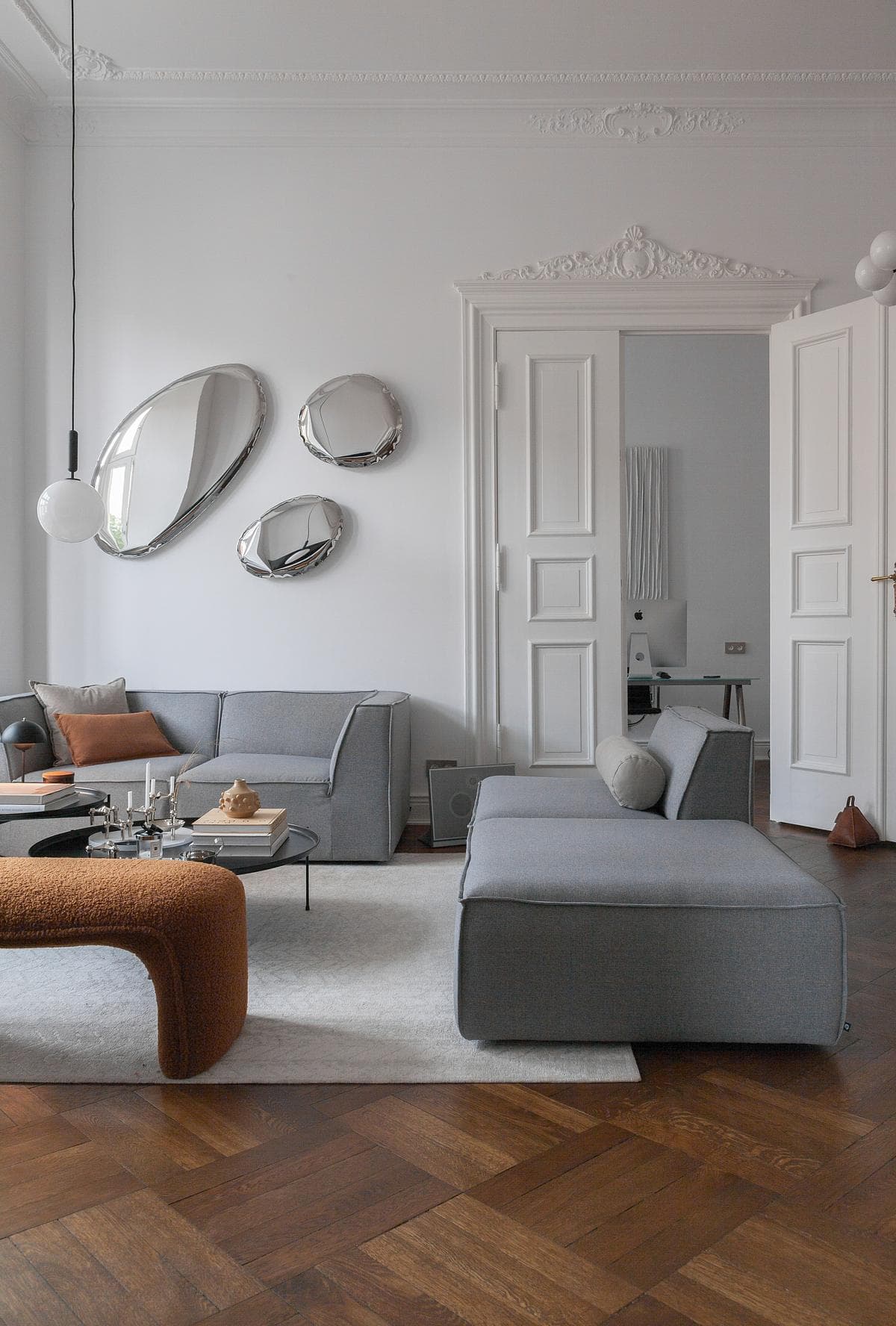 Restored parquet and tall doors connect the lounge with the adjoining room.
